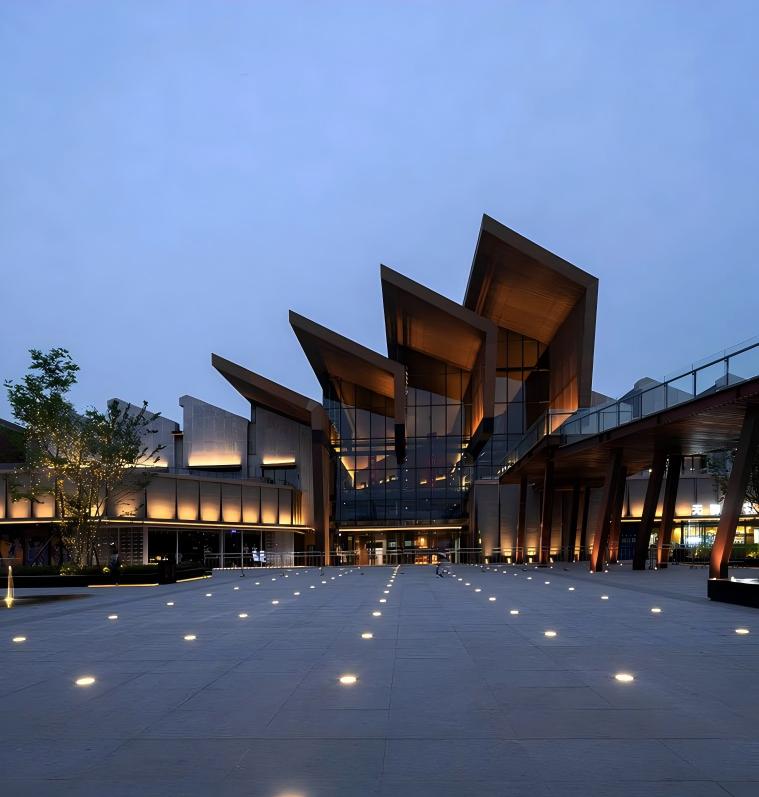Modern commercial building facade illuminated by warm LED architectural lighting at dusk, showcasing elegant exterior and landscape lighting design